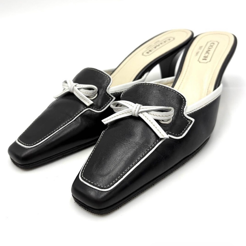 Coach black mules with white trim and a white bow